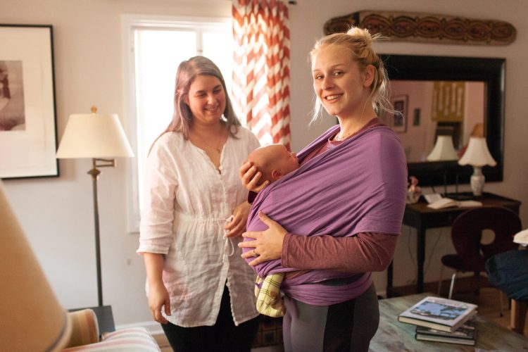 postpartum doula supporting client with babywearing